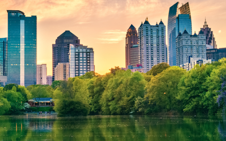 A body of water with trees and buildings in the background.