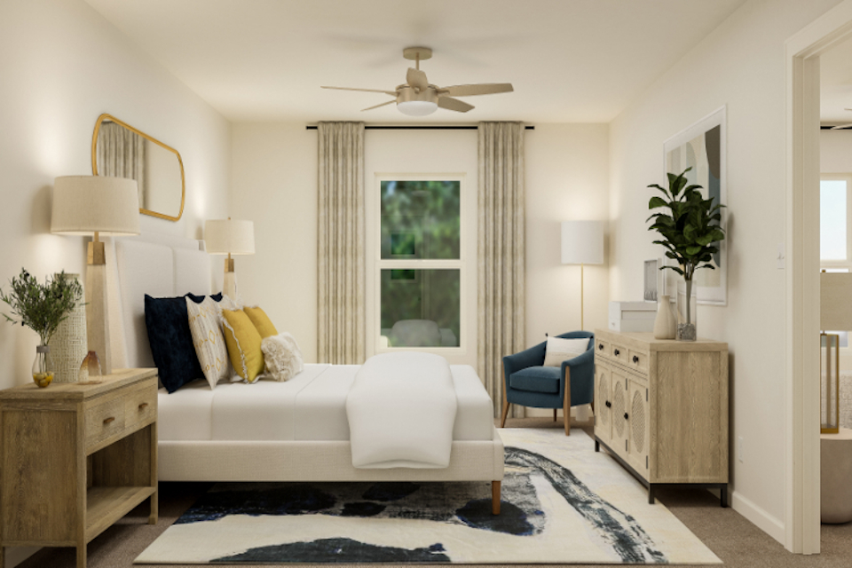 A living room with a white couch and a fan.
