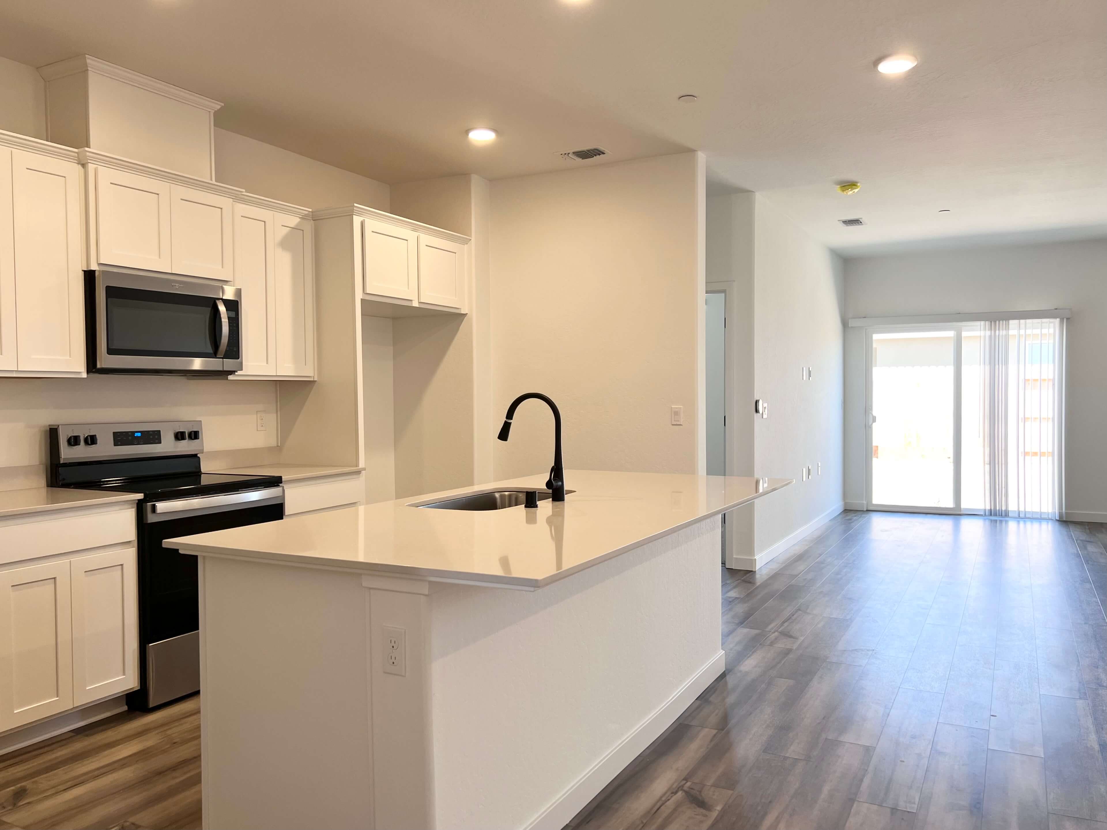 A kitchen with white cabinets.