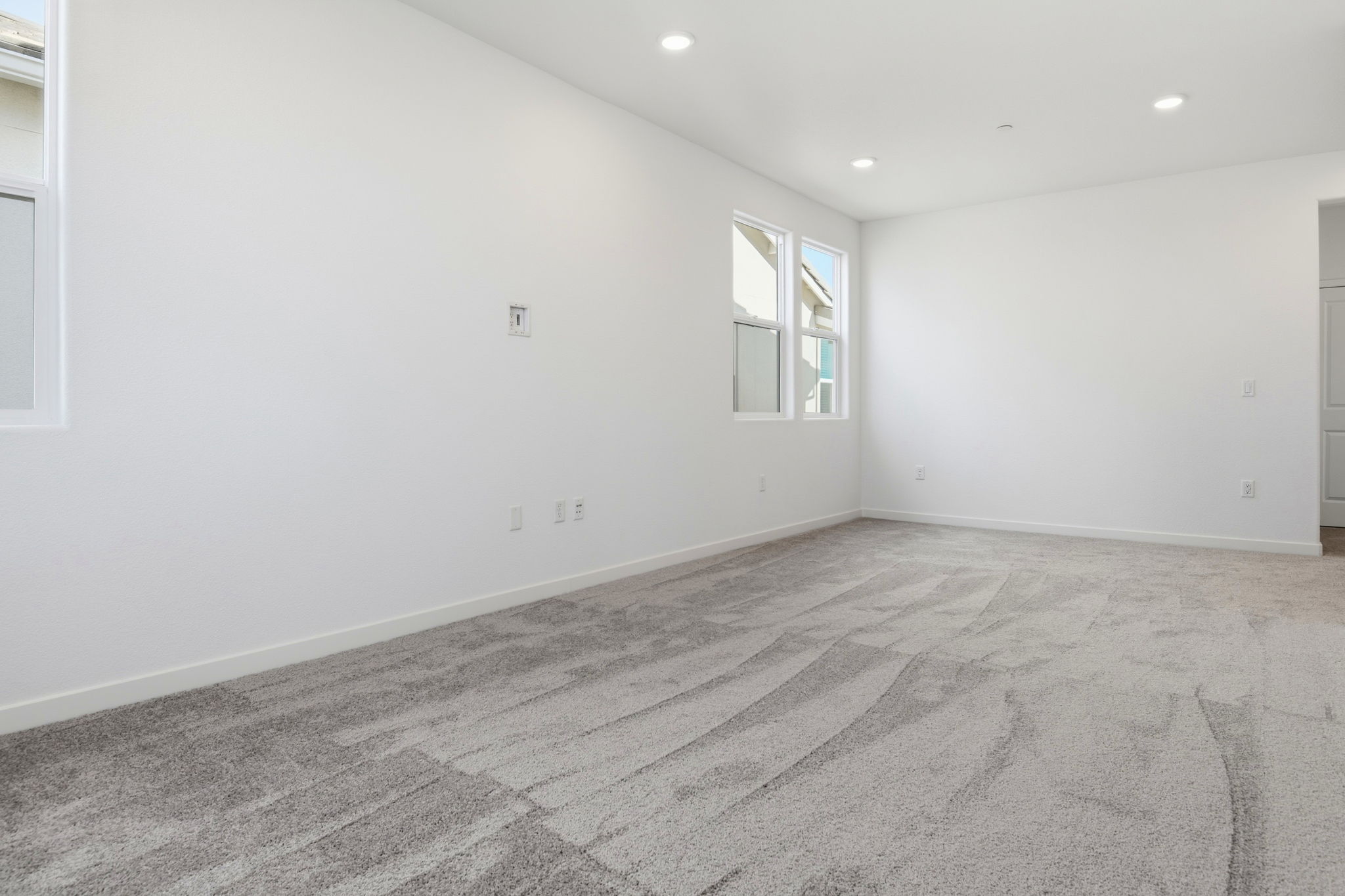 A room with a carpet and windows.