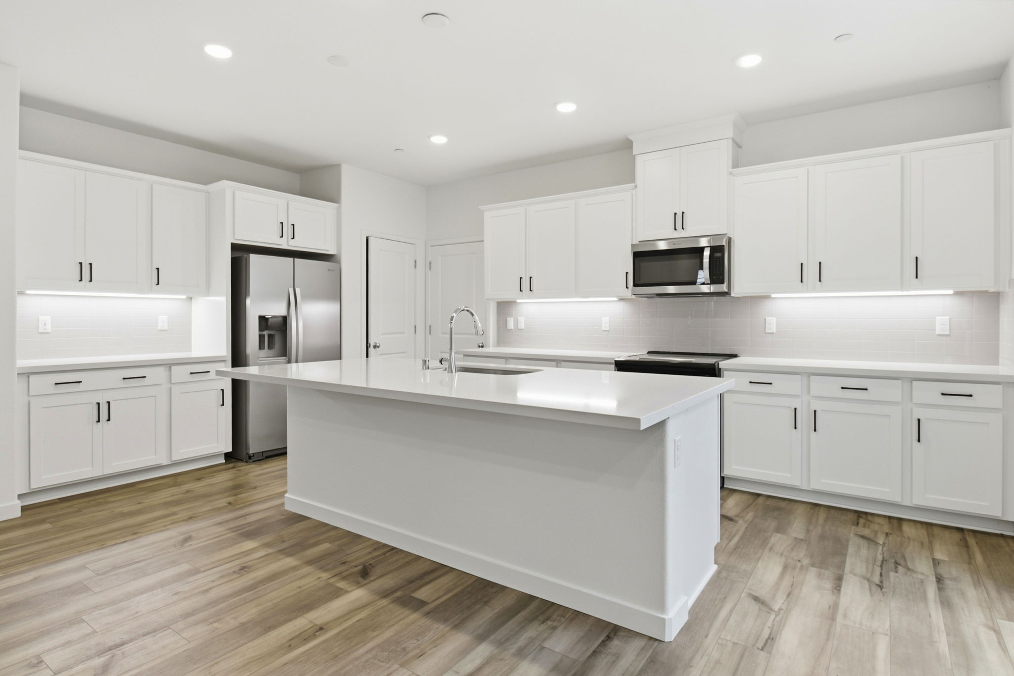 A kitchen with white cabinets.