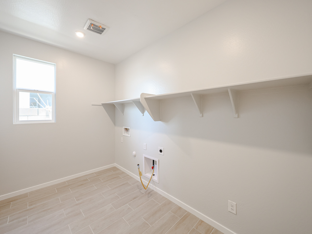 A room with a white wall and a wood floor.