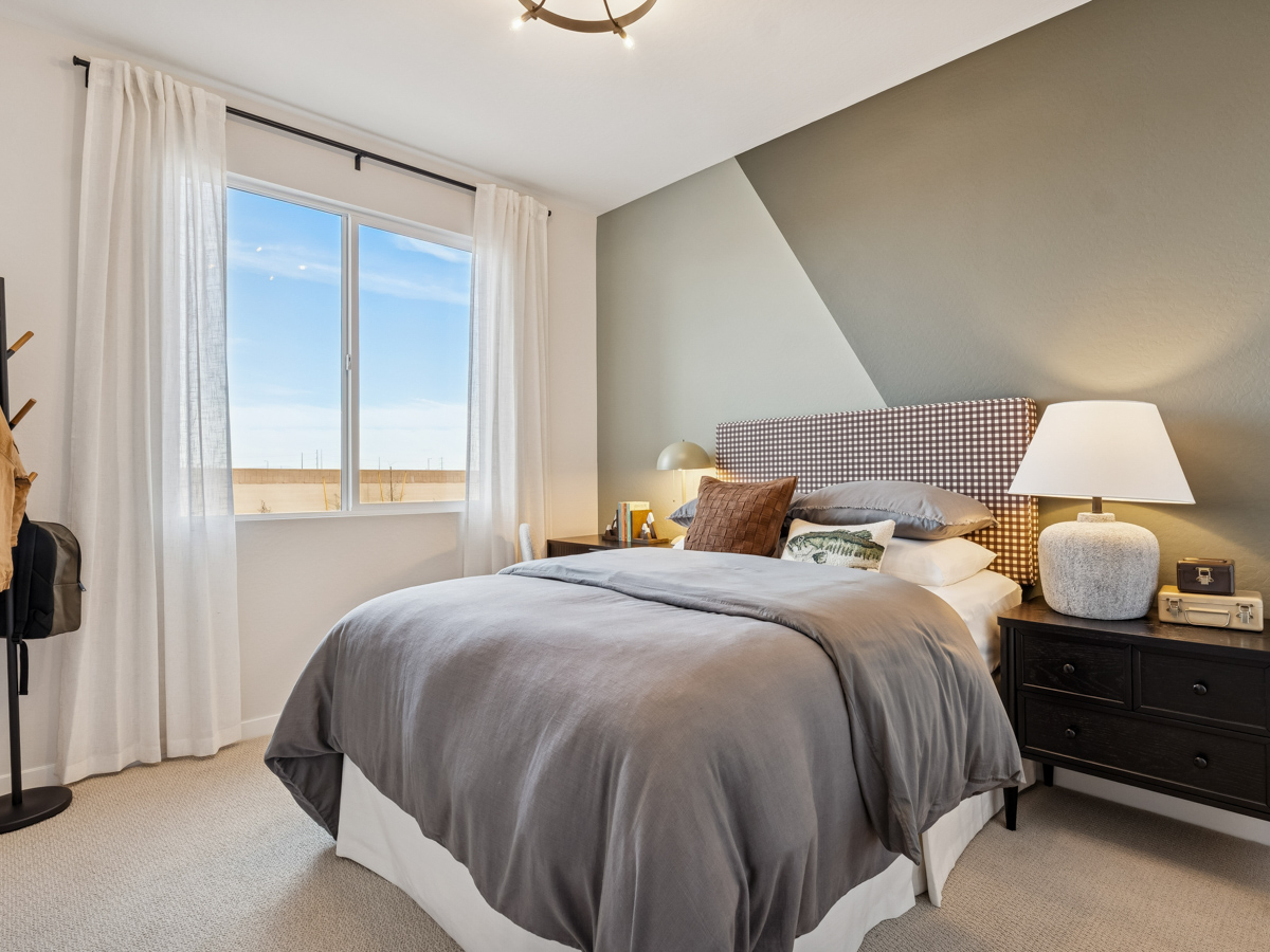 A bedroom with a large window.