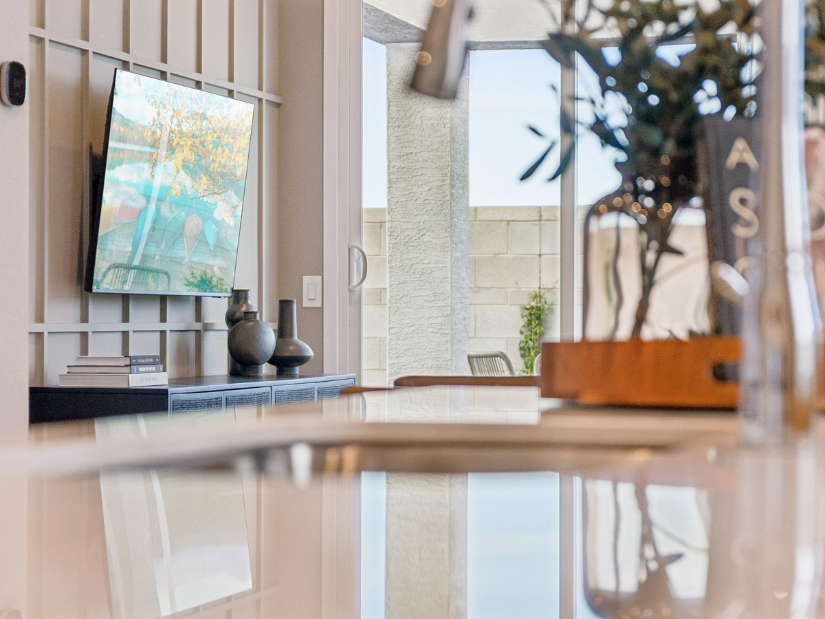 A kitchen counter with a vase and a painting on the wall.