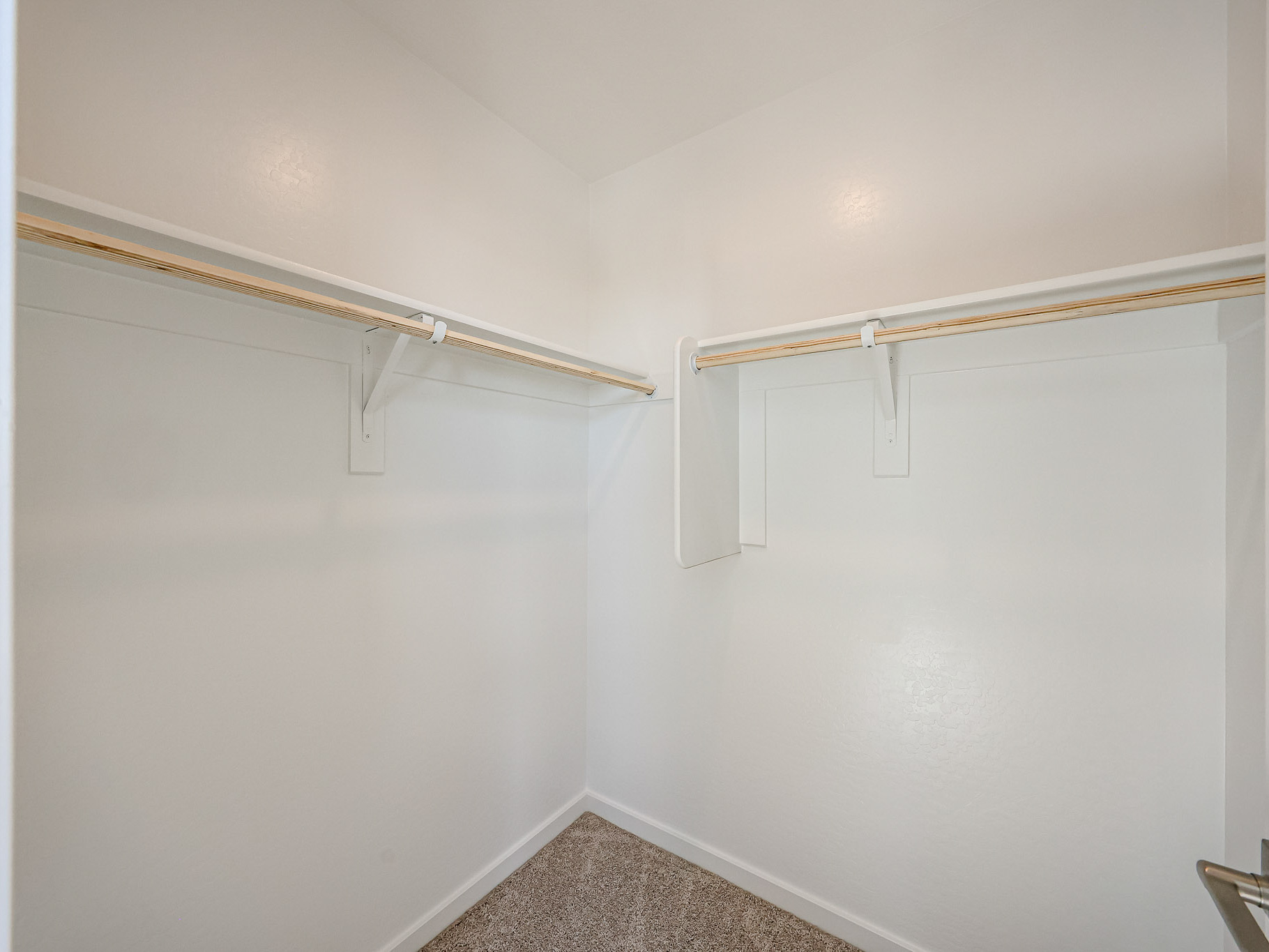 A white wall with a metal bar.