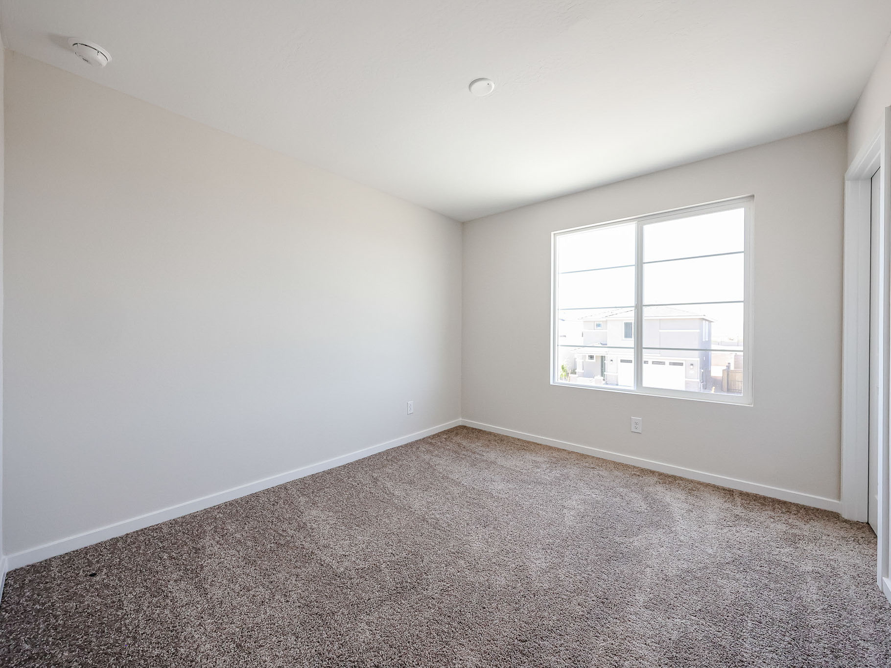 A room with a window and carpet.