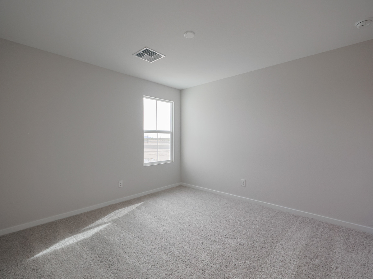 A room with a window and a carpet.