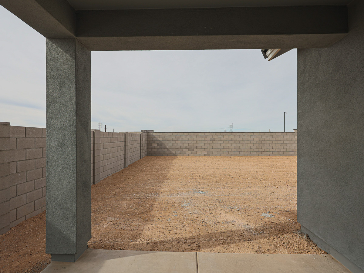 A concrete wall with a dirt field.