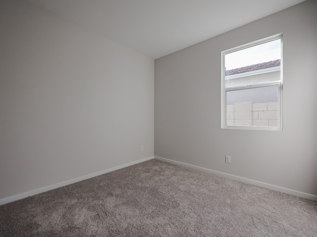 A room with a window and carpet.