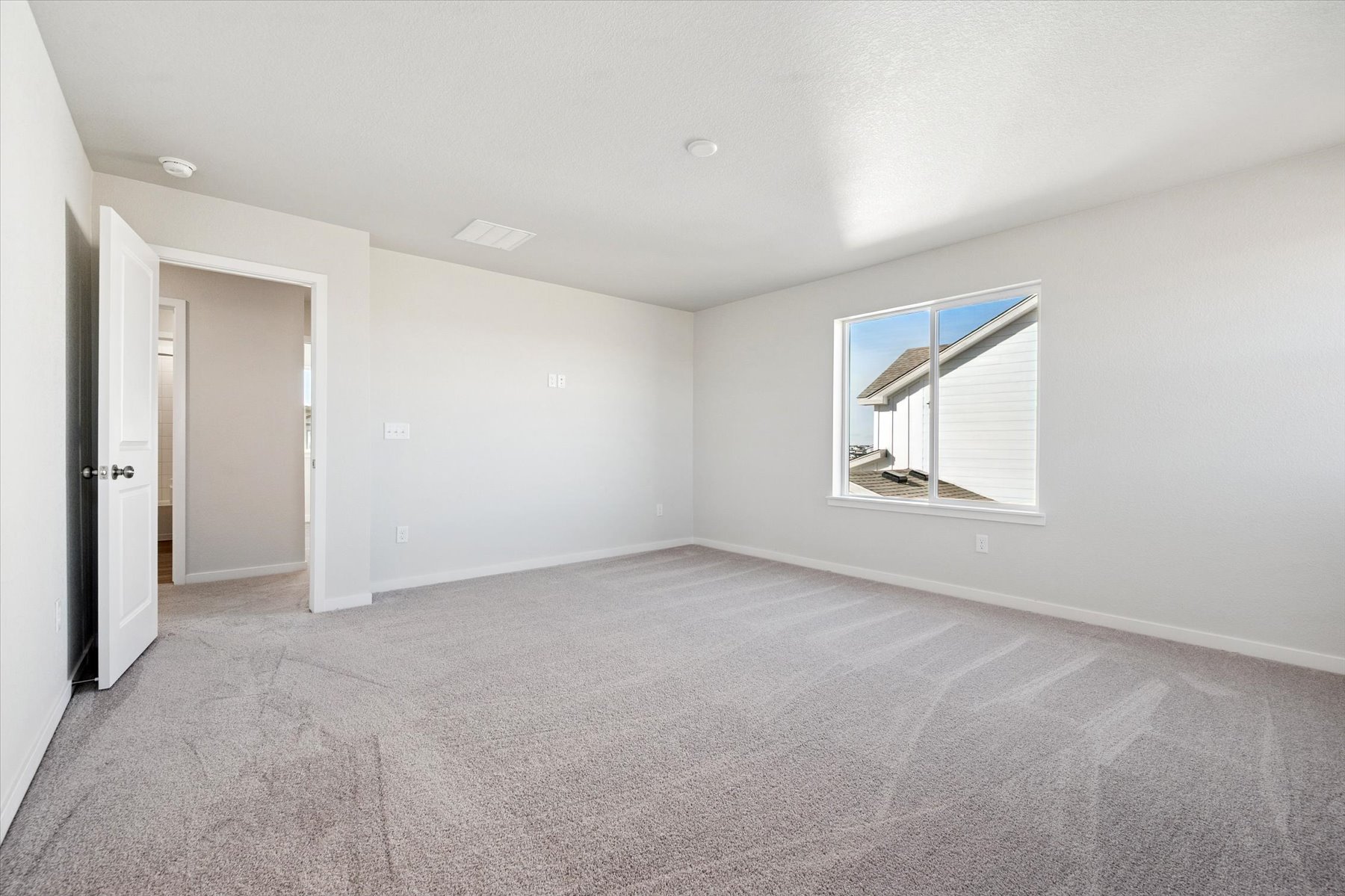 A room with a carpet and a window.