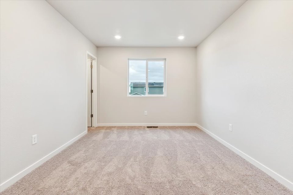 A room with a window and a carpet.