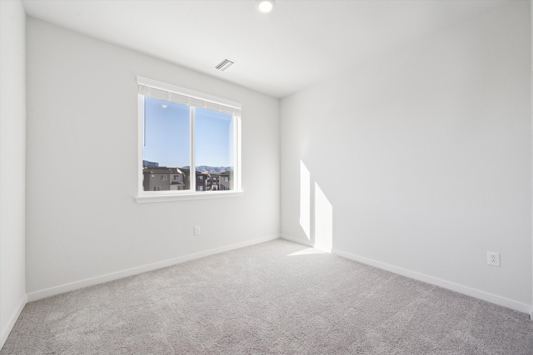A room with a window and a carpet.