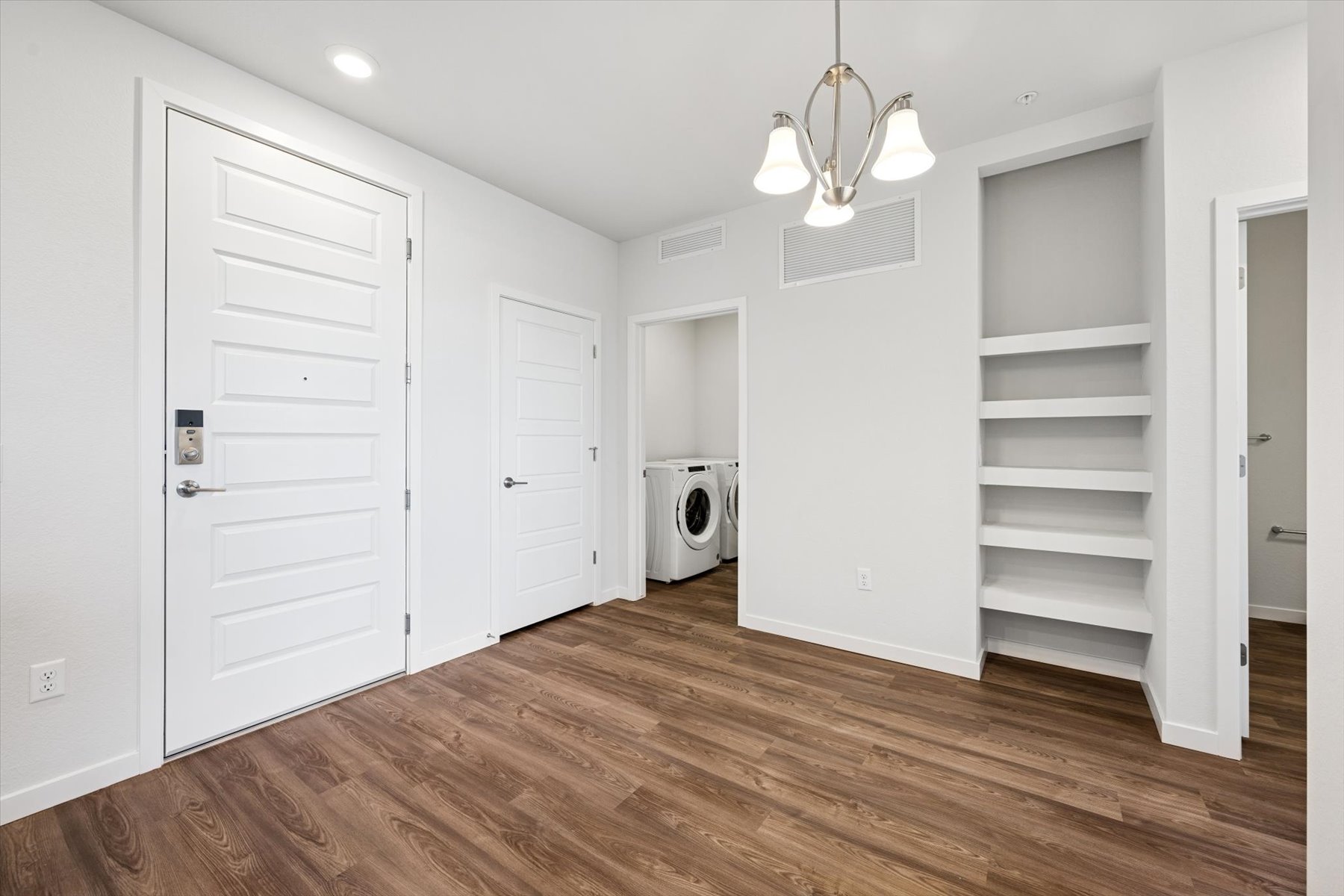 A room with white cabinets and a white door.