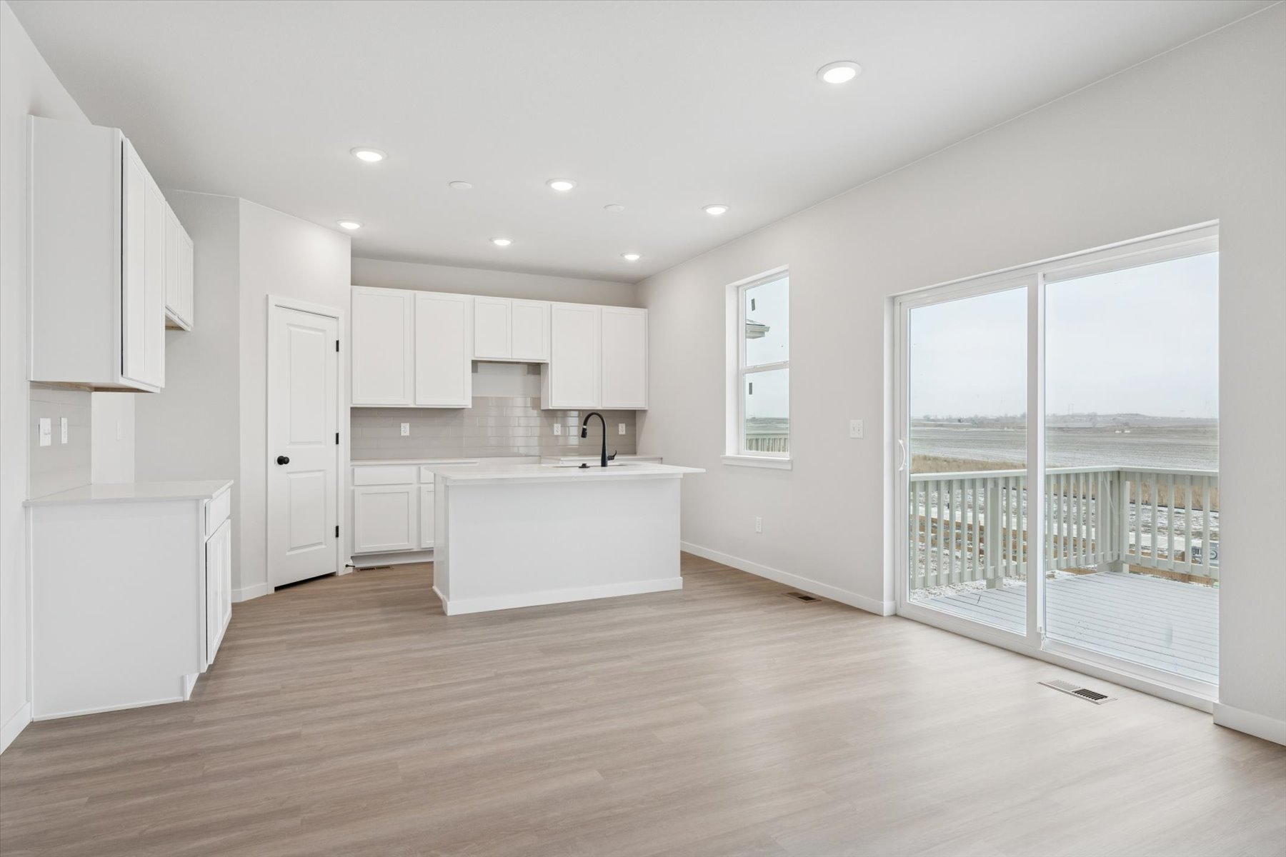 A kitchen with white cabinets.