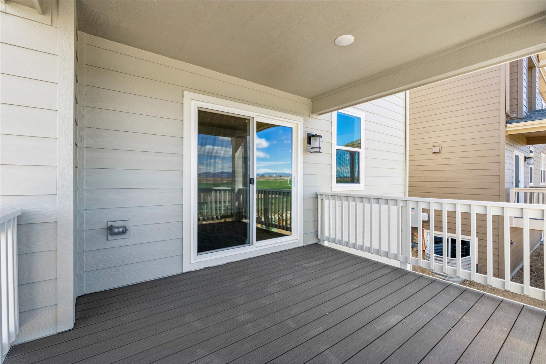 A deck with a railing and a wood deck with a white railing.