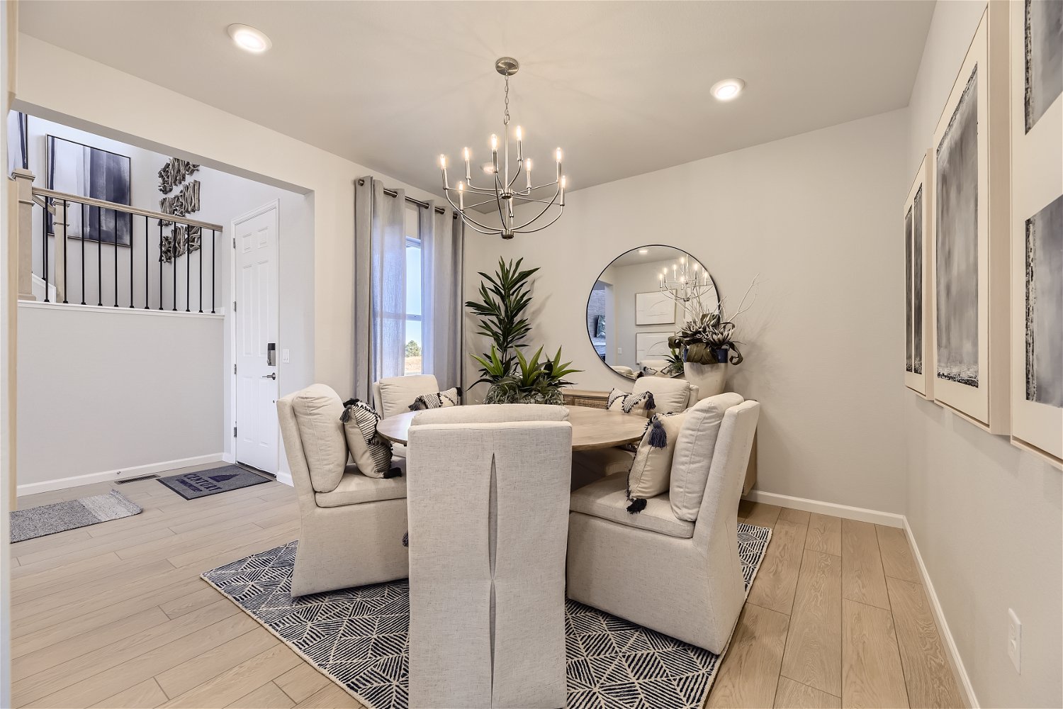A living room with a white couch and a round mirror.