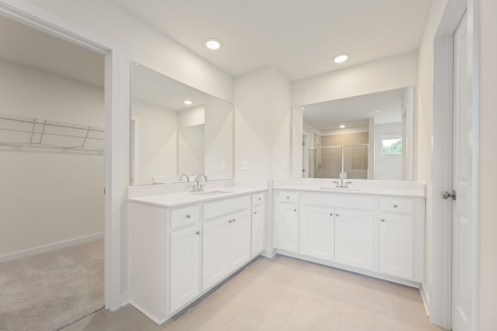 A bathroom with white cabinets.