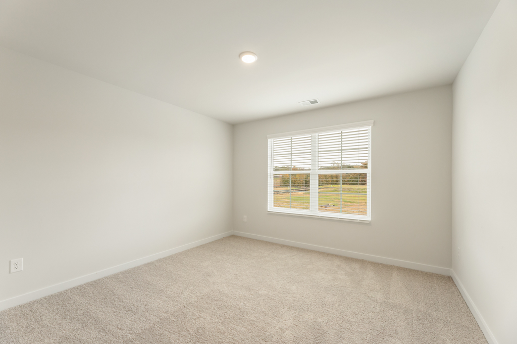 A room with a window and a carpet.