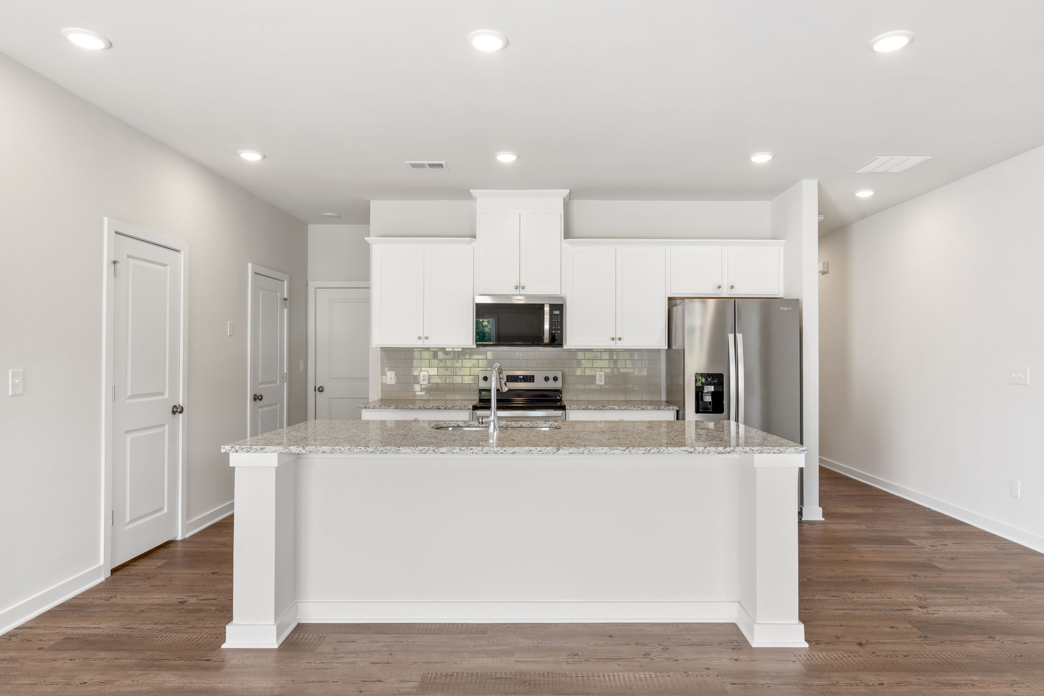 A kitchen with white cabinets.