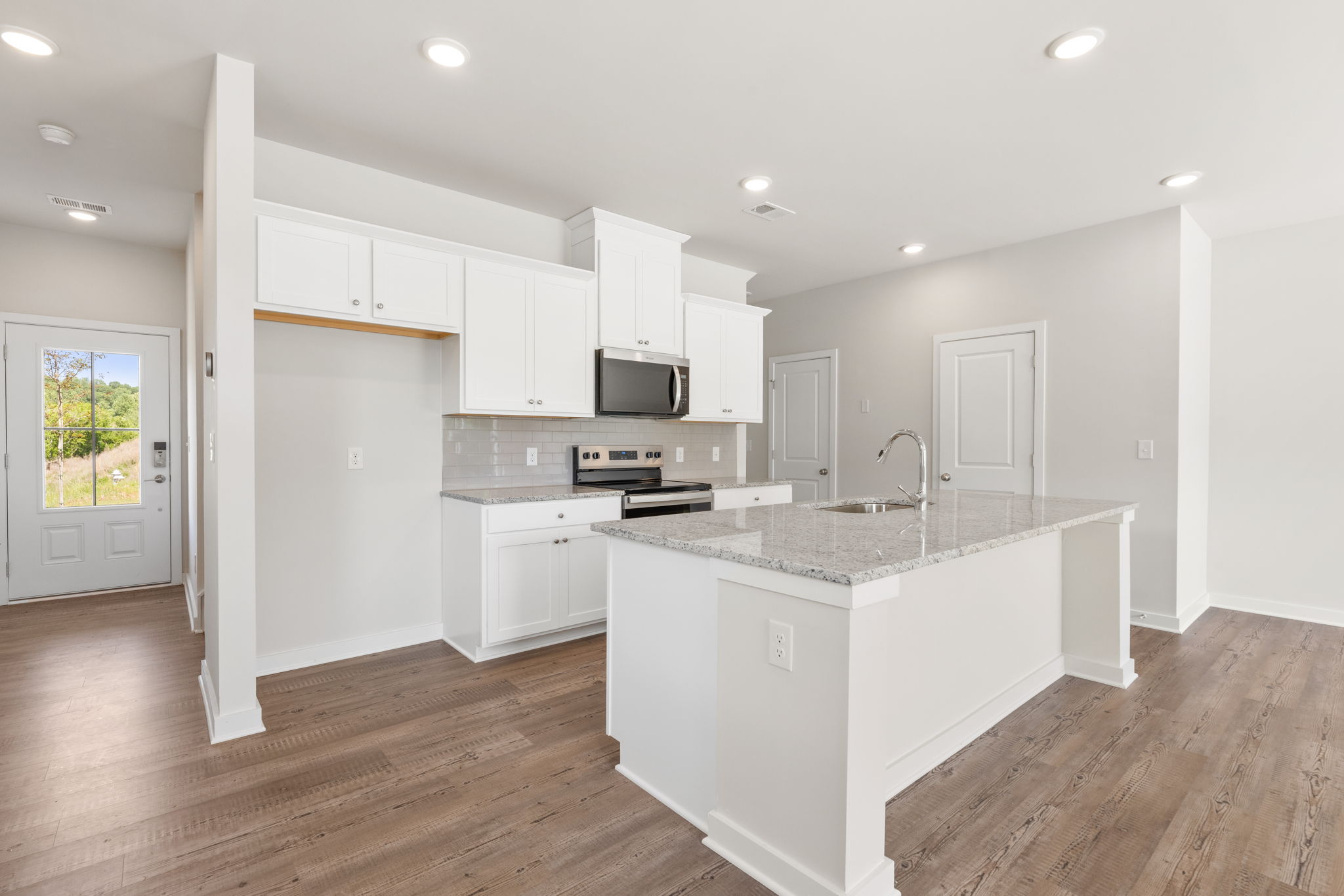 A kitchen with white cabinets.