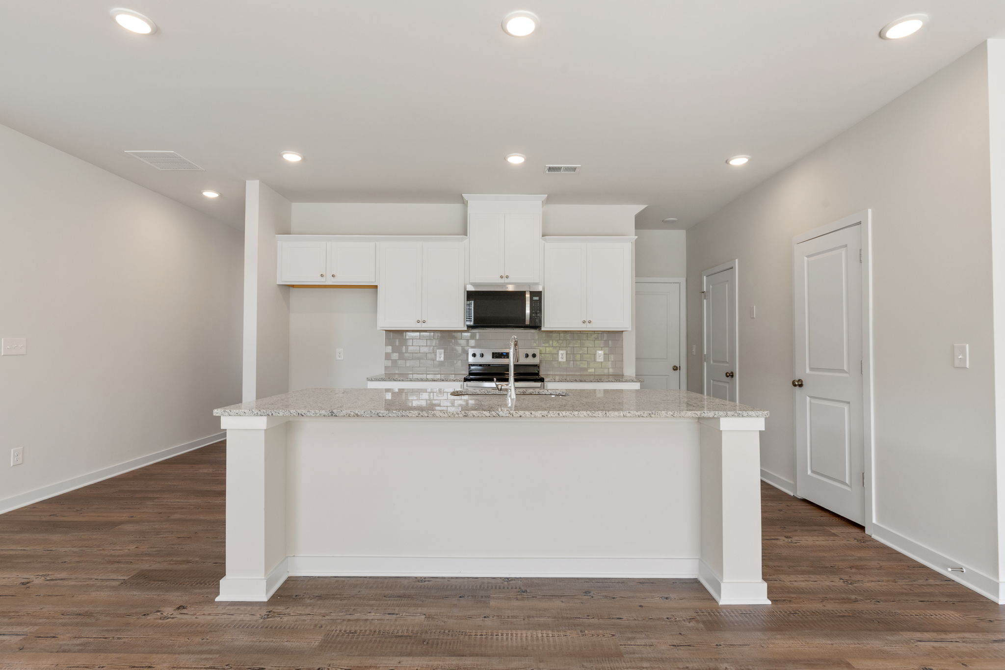 A kitchen with white cabinets.