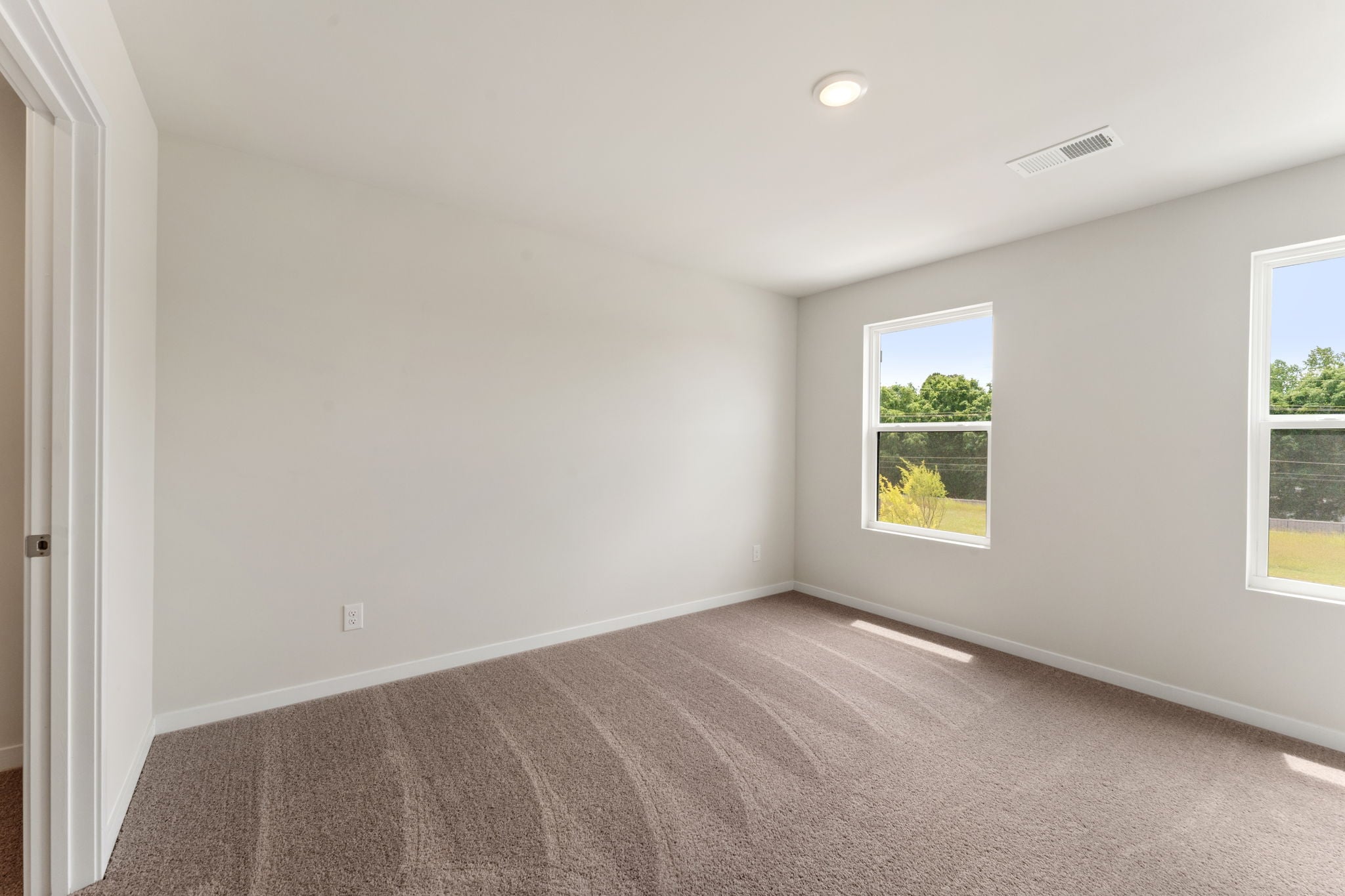 A room with a carpet and windows.
