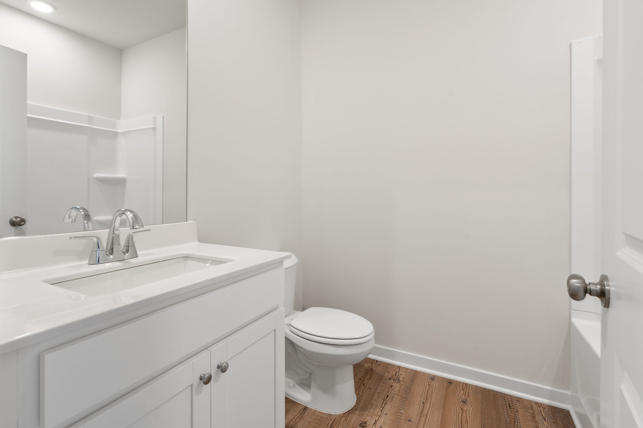 A bathroom with a toilet sink and a mirror.