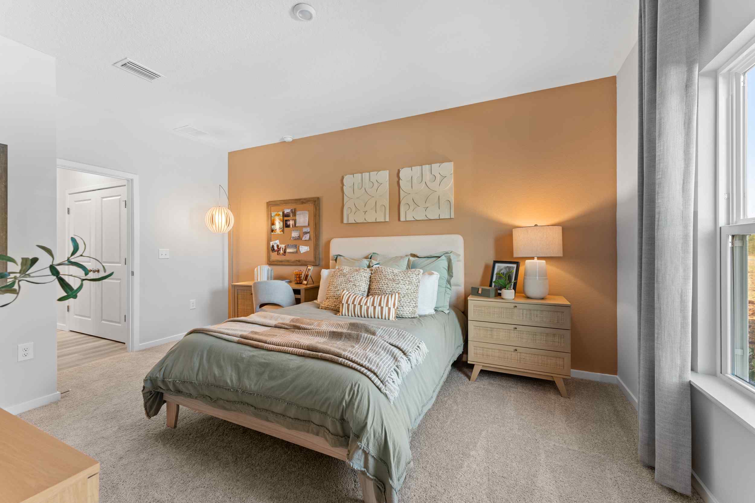 A bedroom with a bed and lamps.