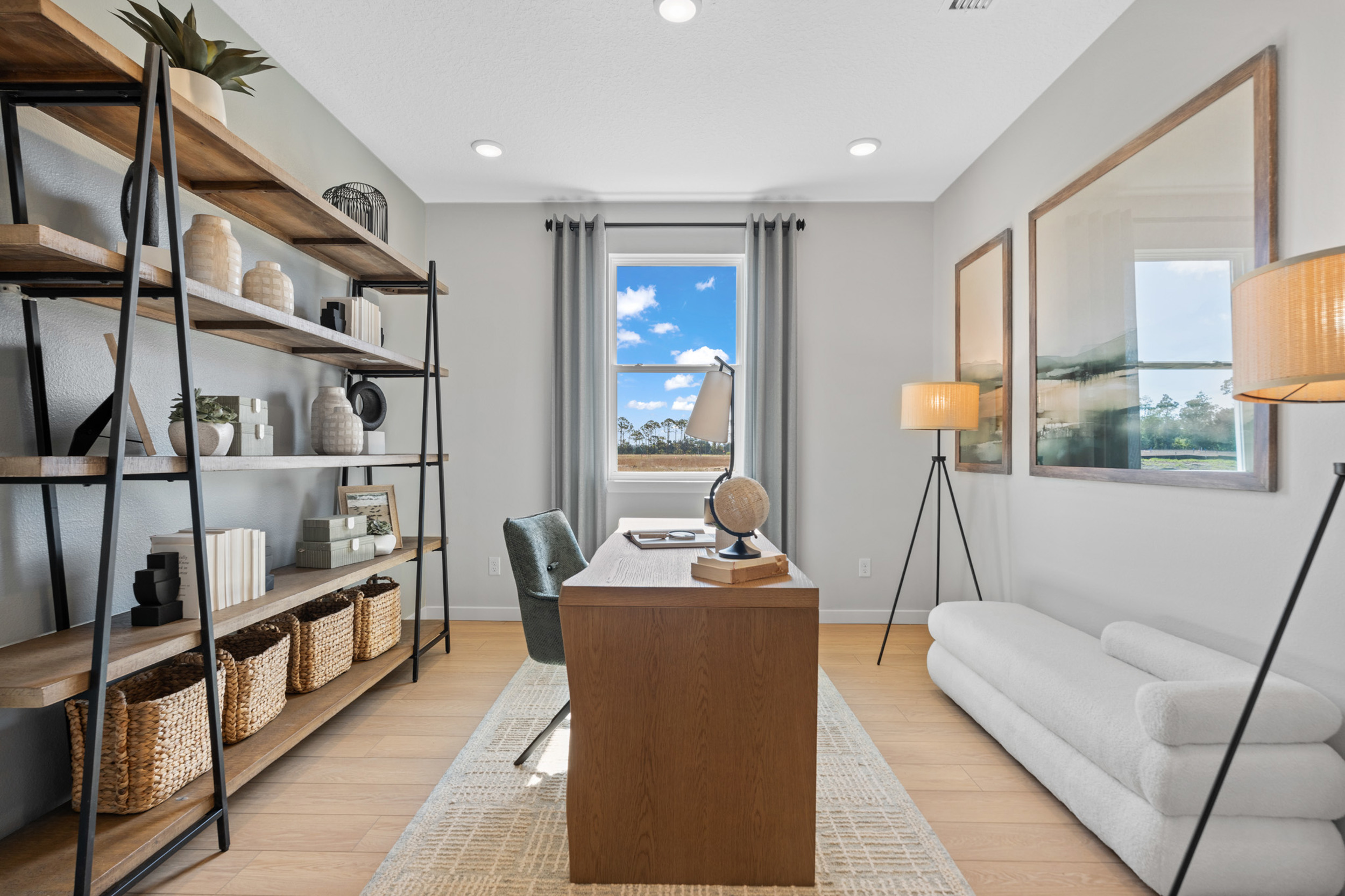 Kenai Model Home Study with Shelving, Desk and Chair, and small couch at Reserve East in Flagler Beach