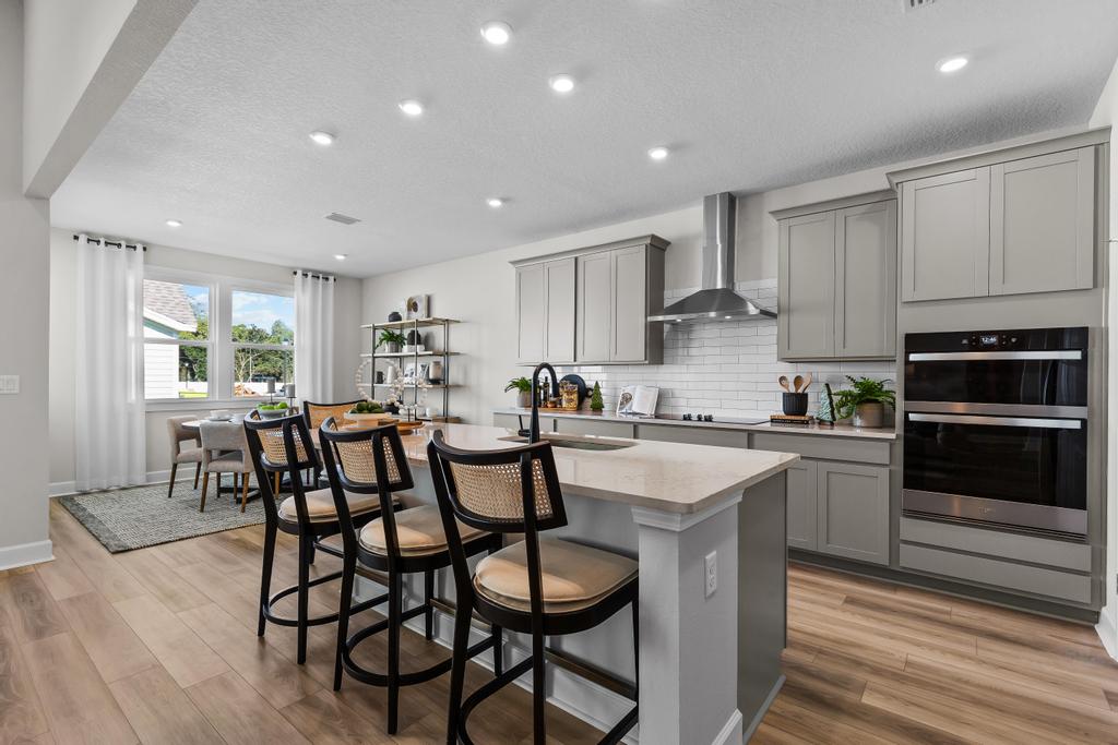 A kitchen with a bar stool and a stove.