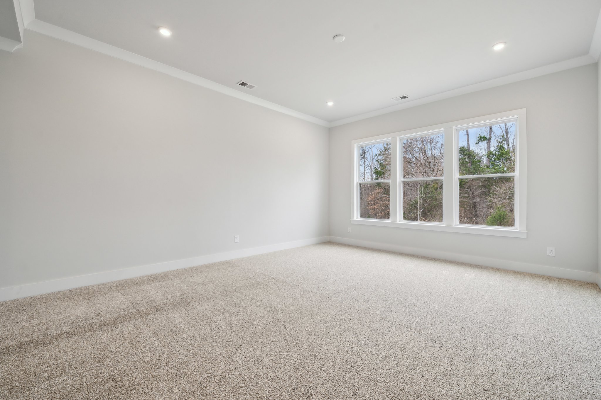 A room with a window and carpet.