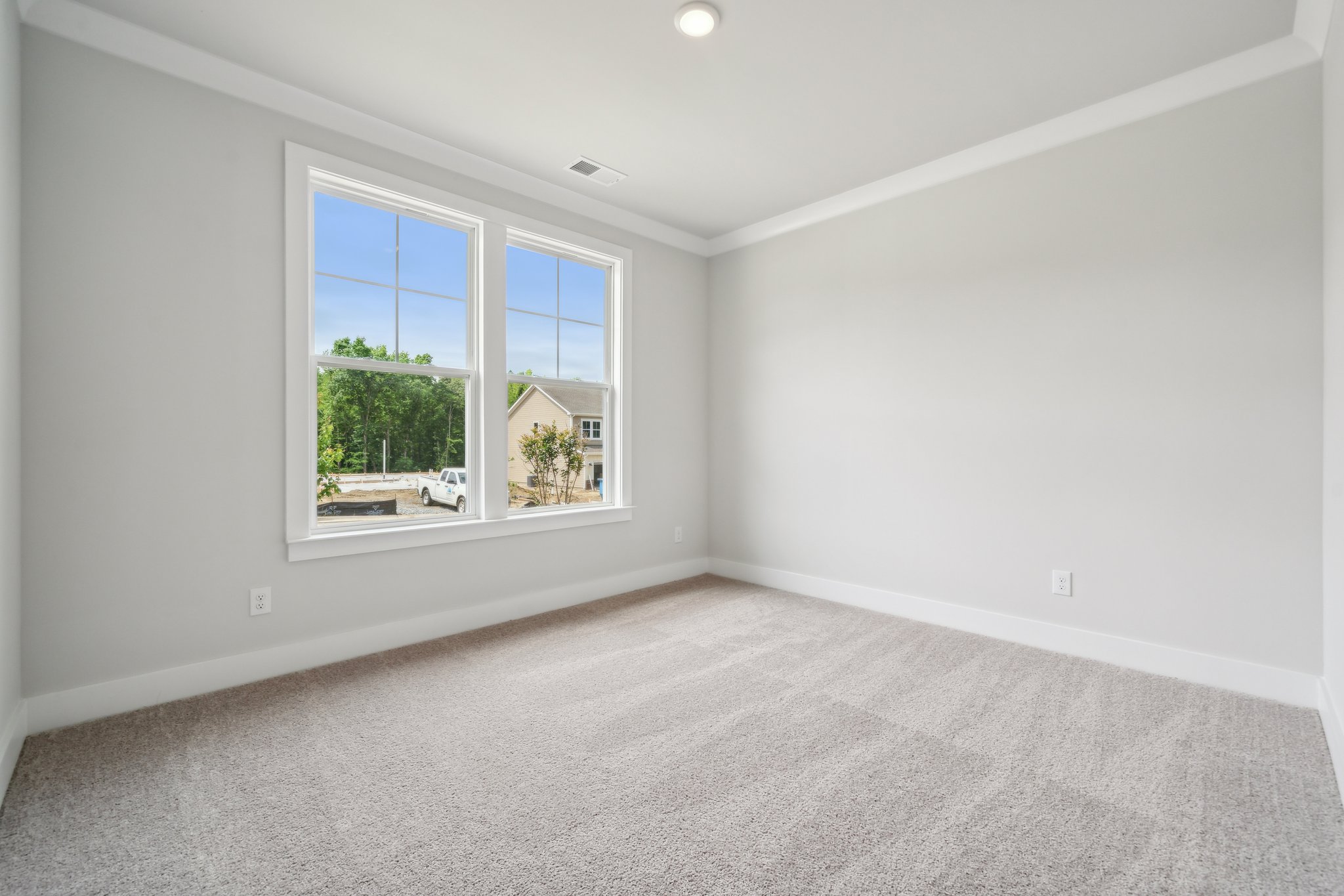 A room with a window and a carpet.