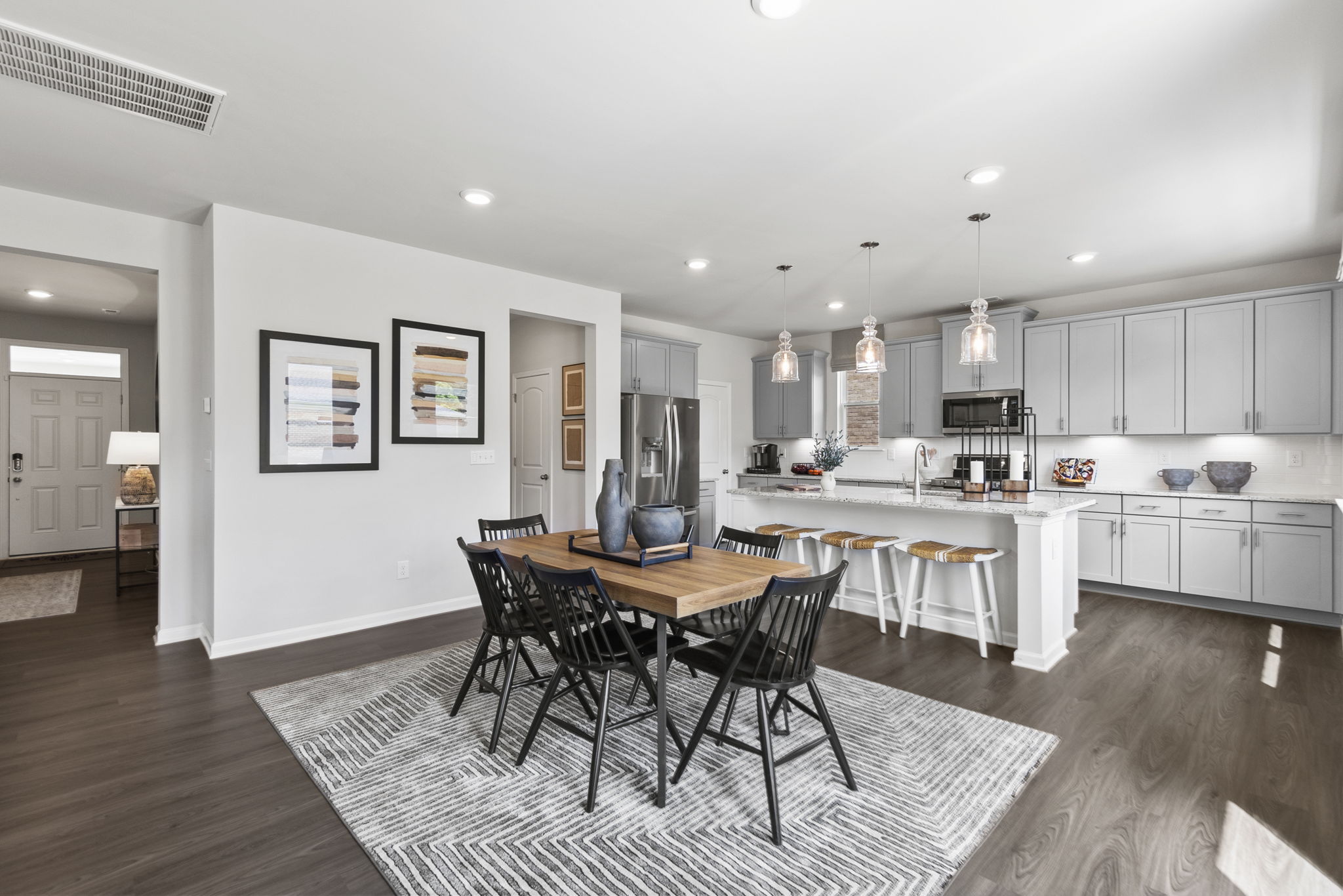 A kitchen with a dining table and chairs.