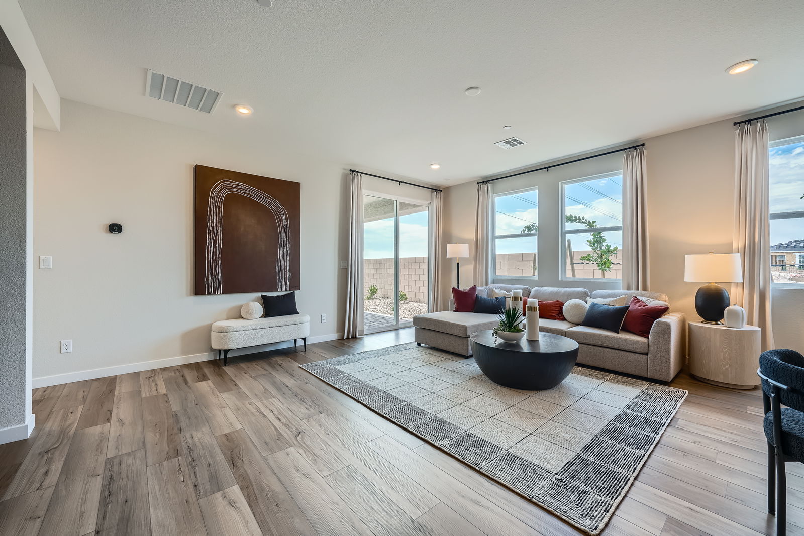 A living room with a rug and a large window.