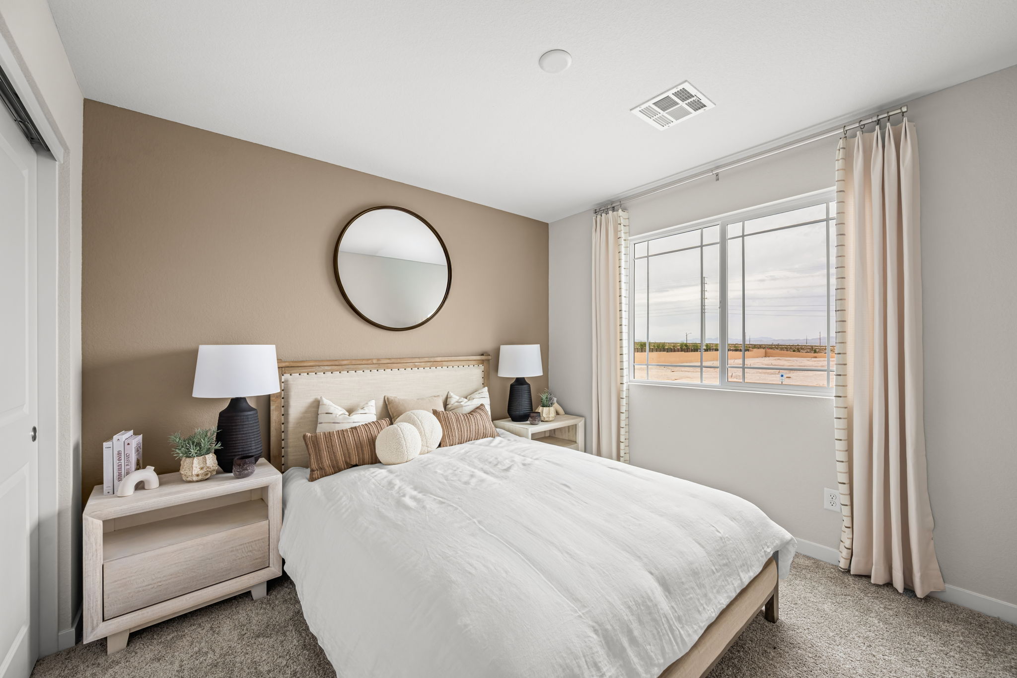 A bedroom with a bed and a mirror.