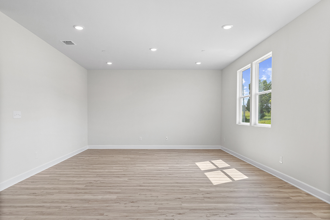 A room with a wood floor and windows.
