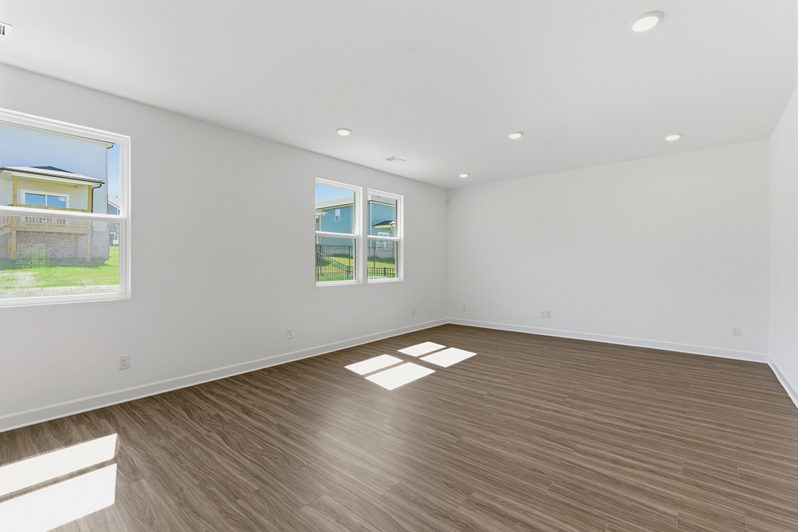 A room with a wood floor and windows.