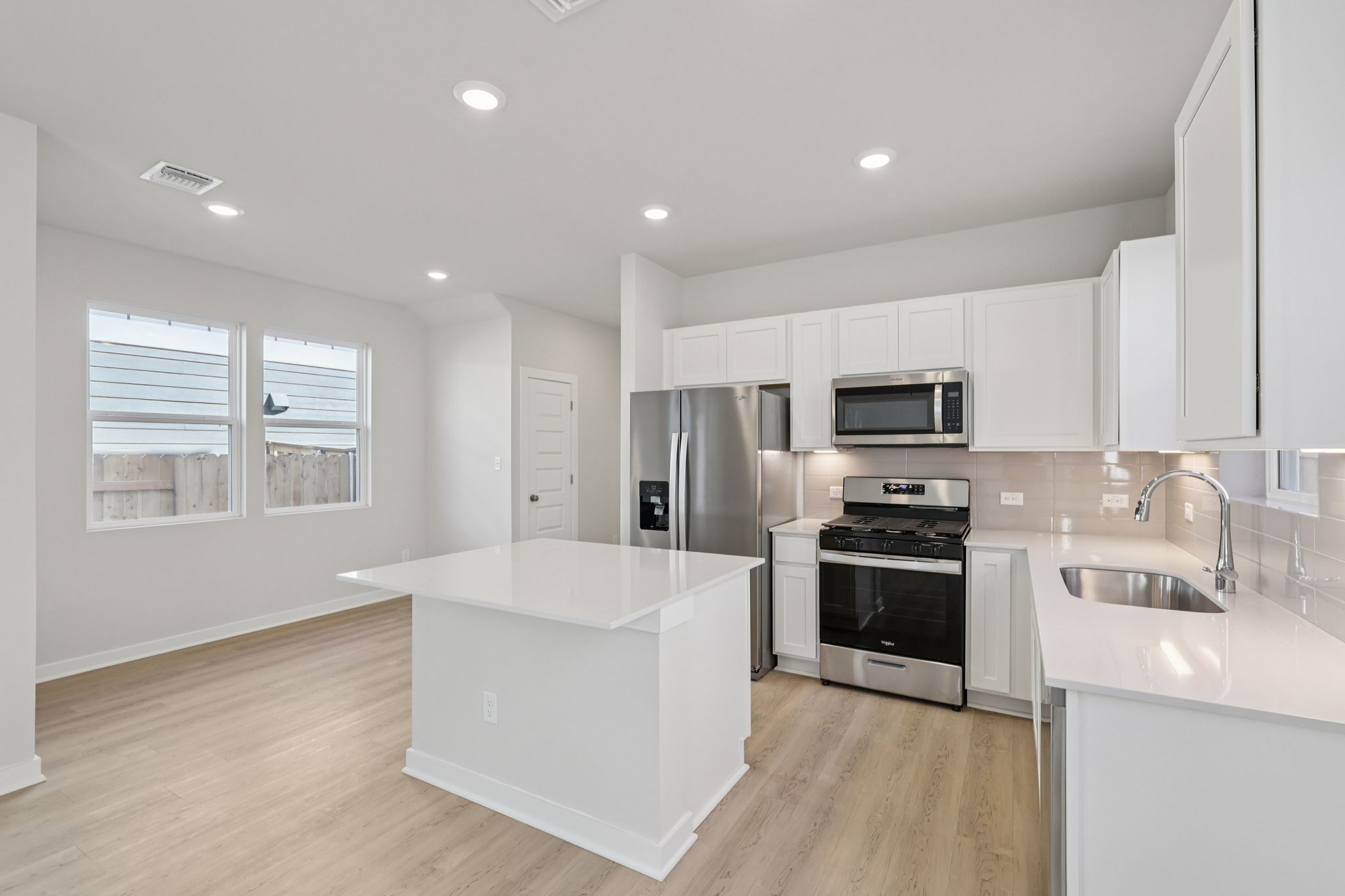 A kitchen with white cabinets.