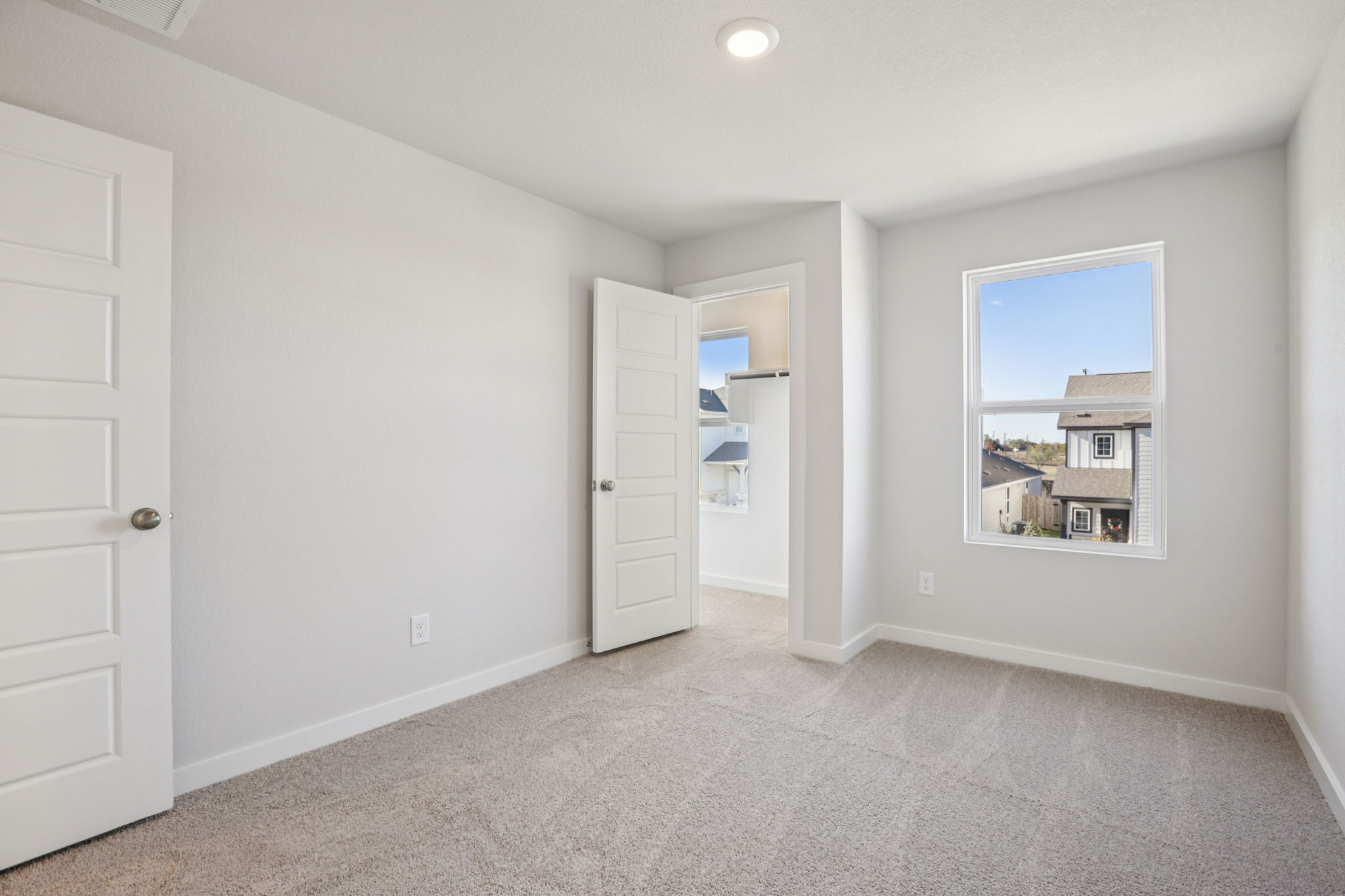 A room with white walls and a window.