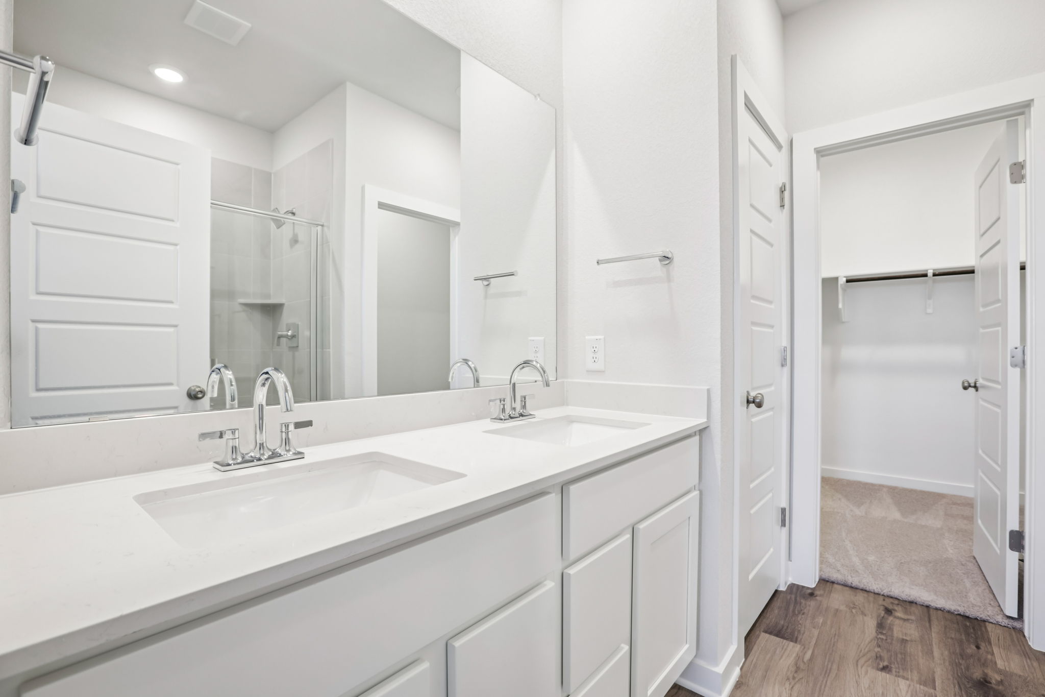 A bathroom with white cabinets.