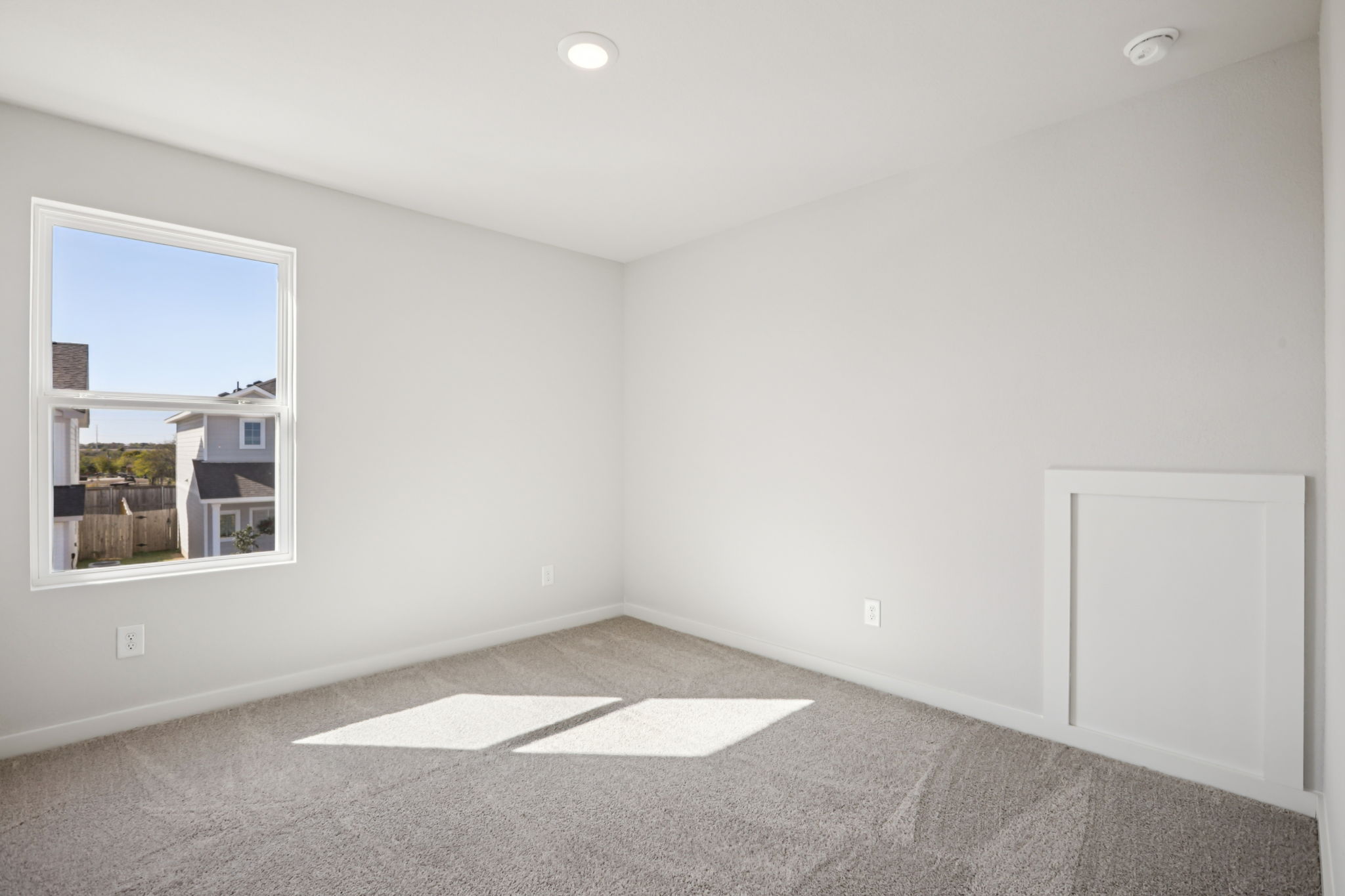 A room with a window and a rug.