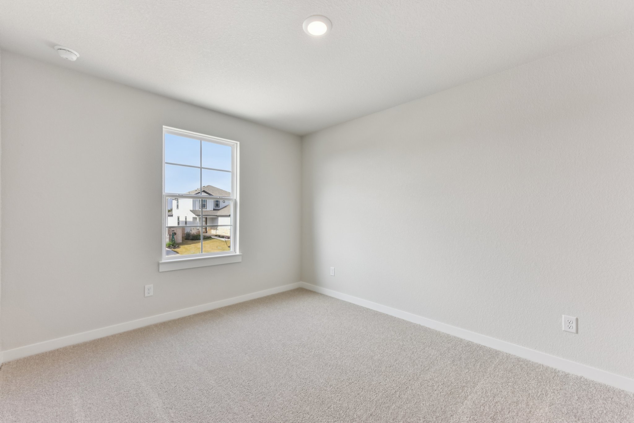 A room with a window and a carpet.