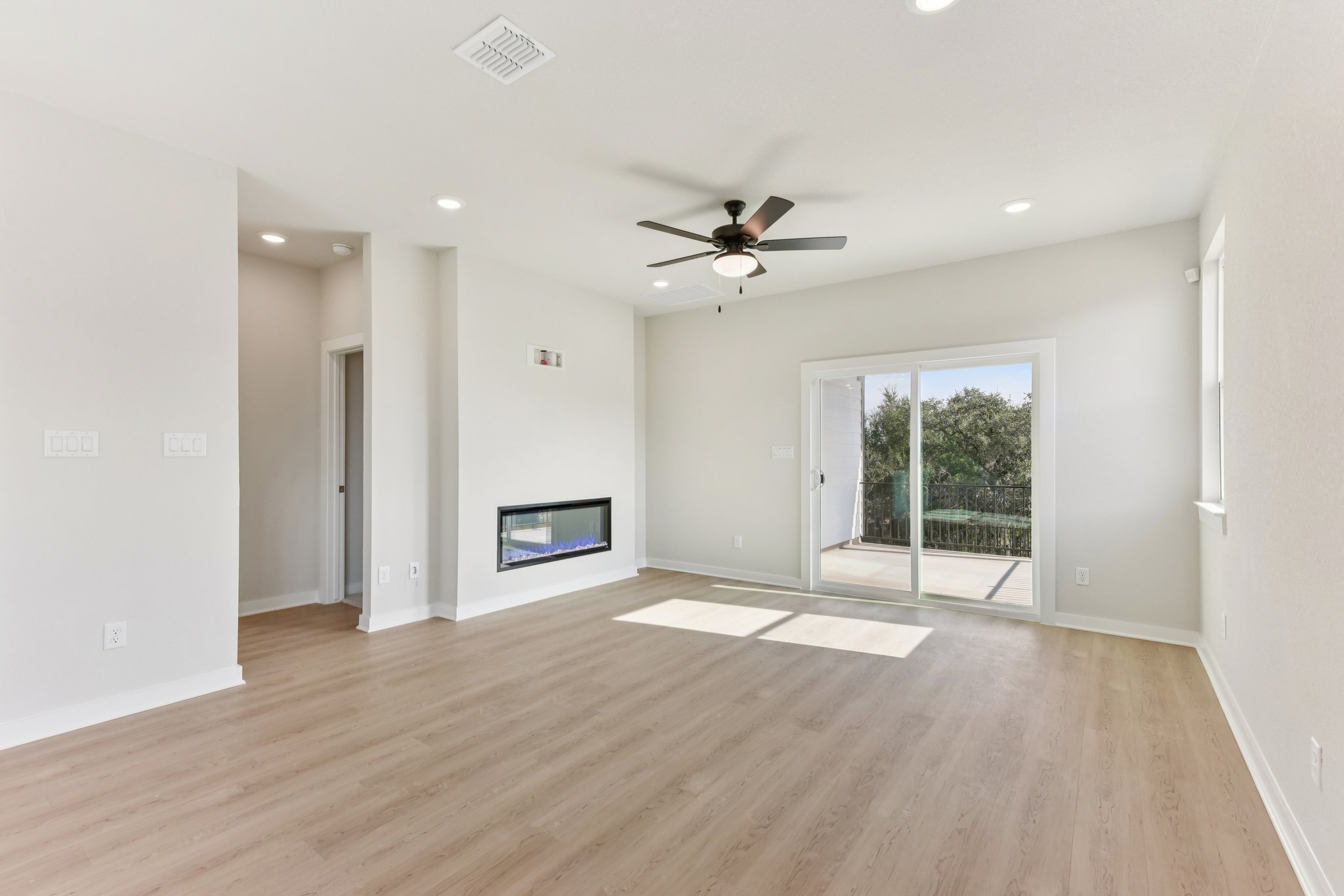 A room with a wood floor and a wood floor with a ceiling fan.
