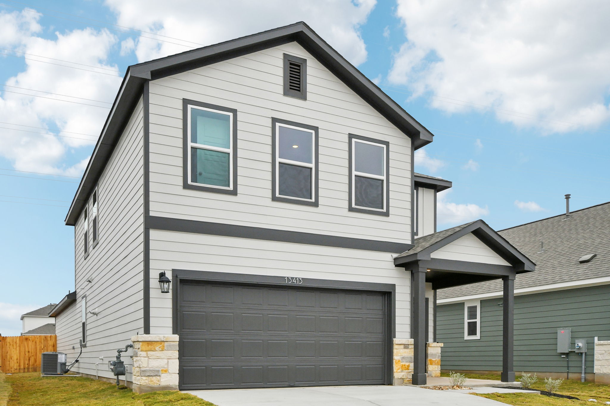 A grey house with a garage.