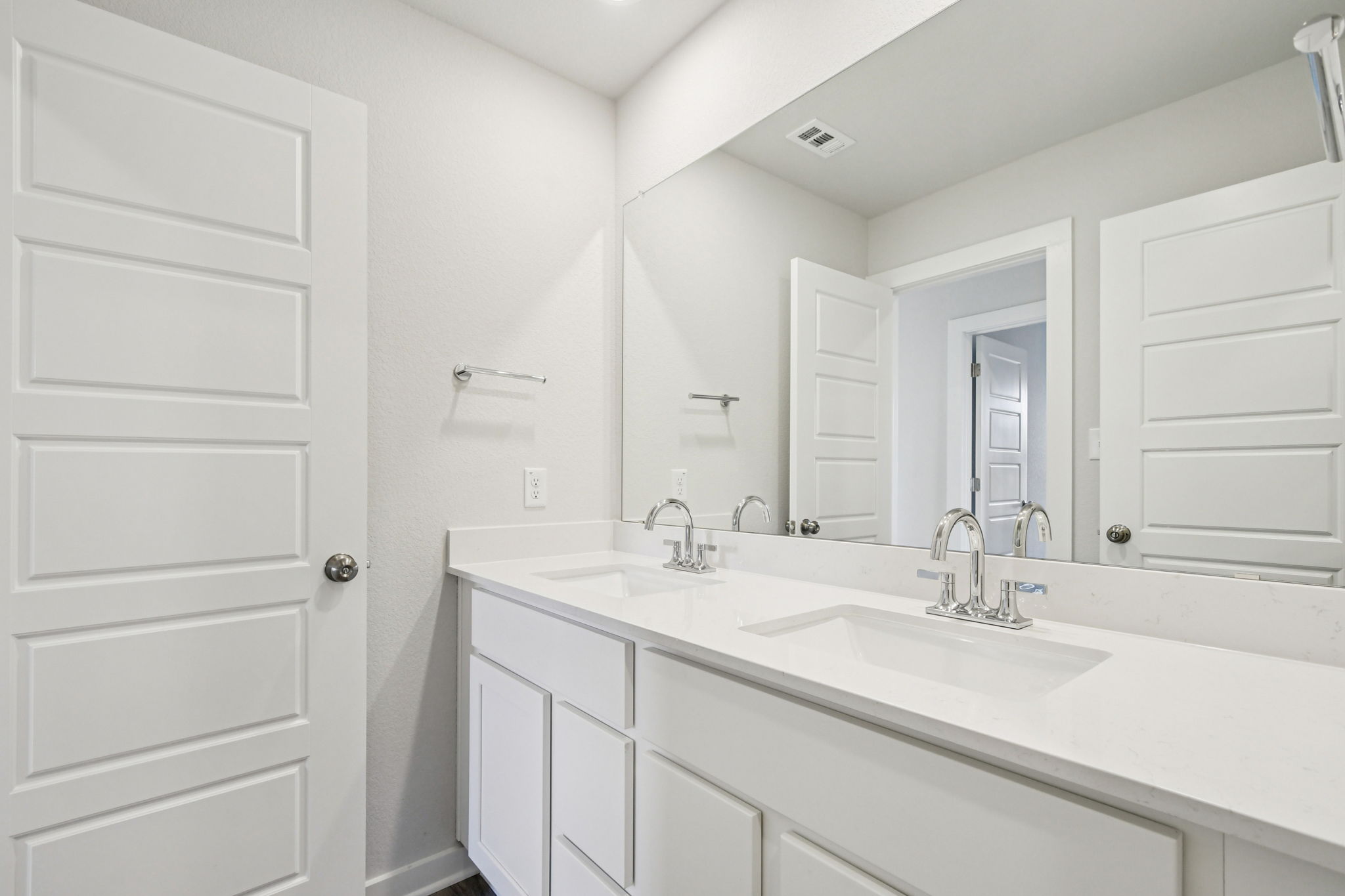 A bathroom with white cabinets.