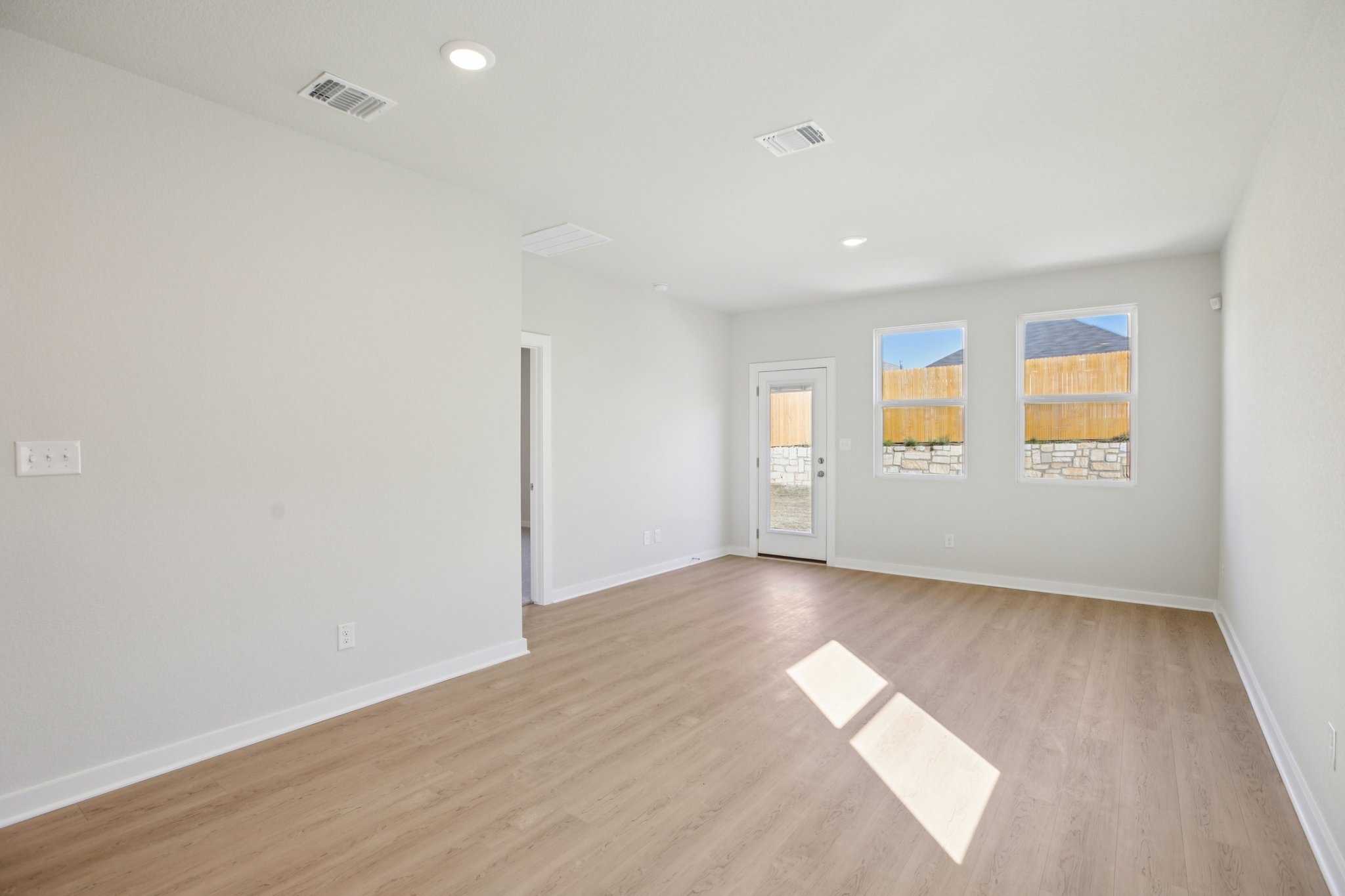 A room with a wood floor and a wood floor with a rug.