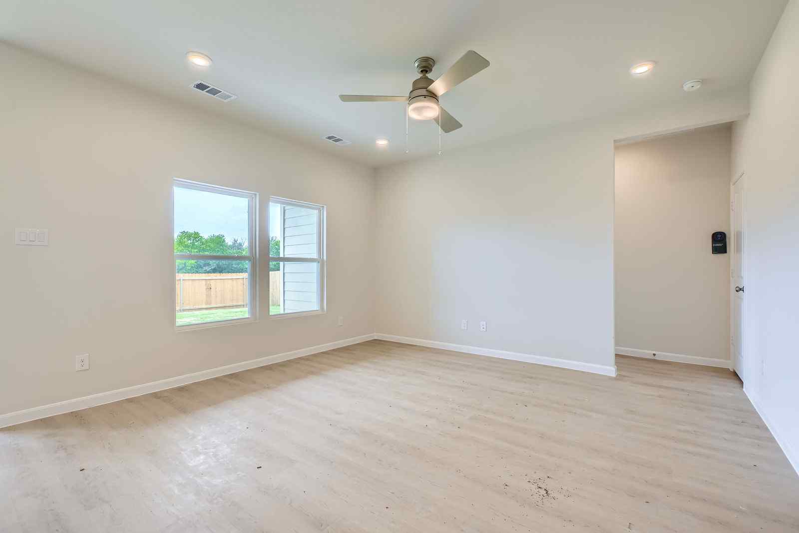 A room with a wood floor and a ceiling fan.