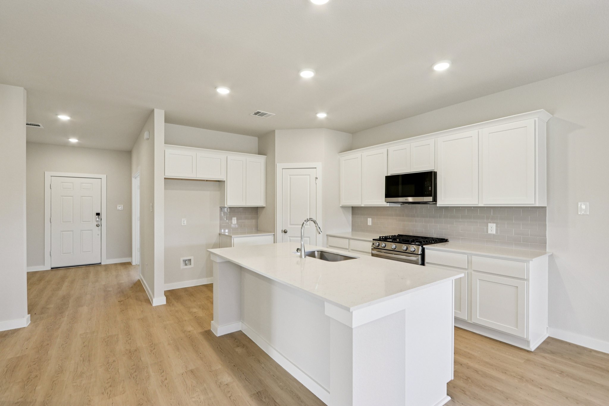 A kitchen with white cabinets.