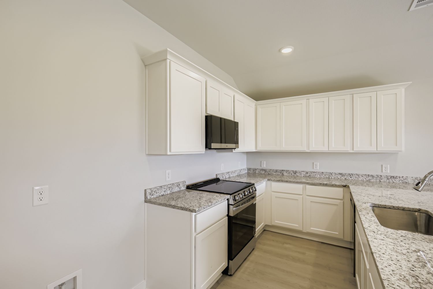 A kitchen with white cabinets.