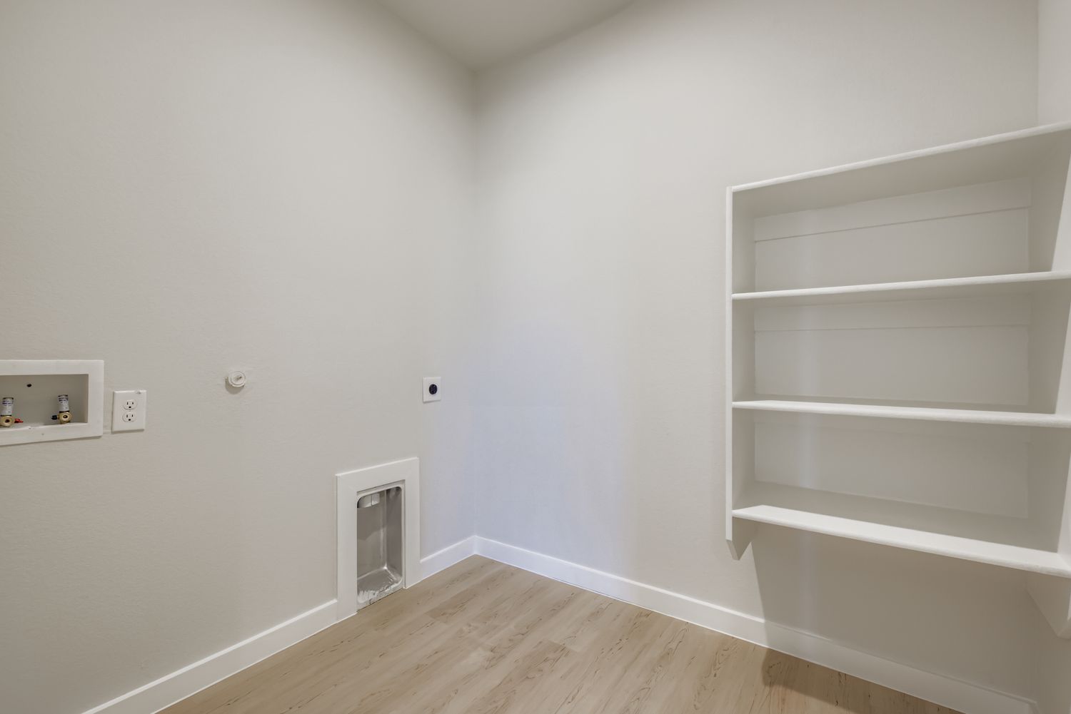 A white room with a white shelf.